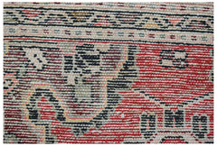 A close-up of a handwoven vintage Persian Sarouk rug featuring intricate red and black patterns.