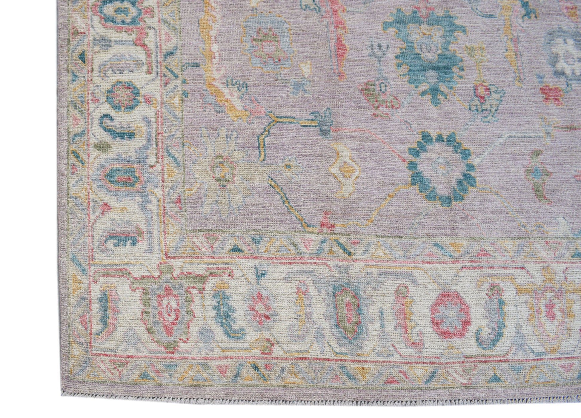 A handmade Afghan Oushak rug featuring a traditional floral pattern in soft pastel tones.
