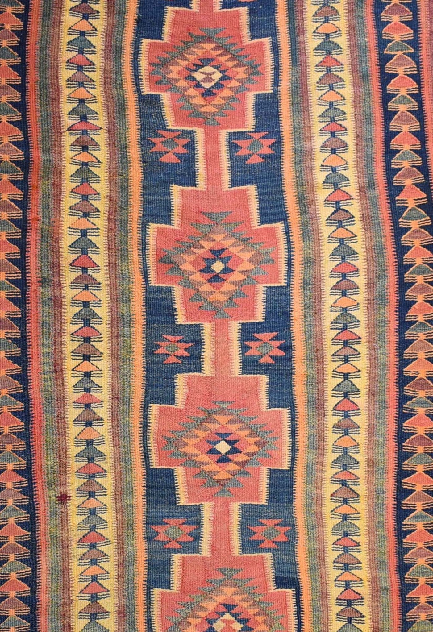 Handmade Persian tribal kilim rug featuring geometric diamond motifs in red, blue, and yellow.