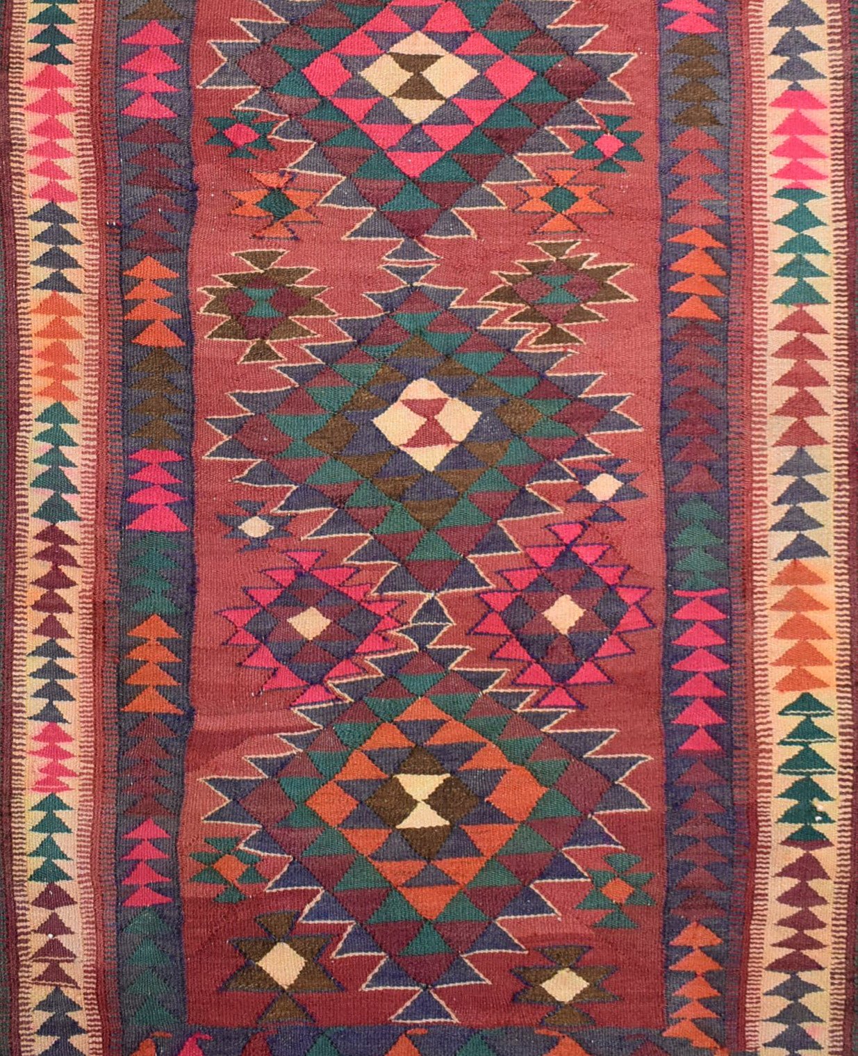 Handmade Persian tribal kilim rug featuring a geometric pattern in red, orange, and teal wool.