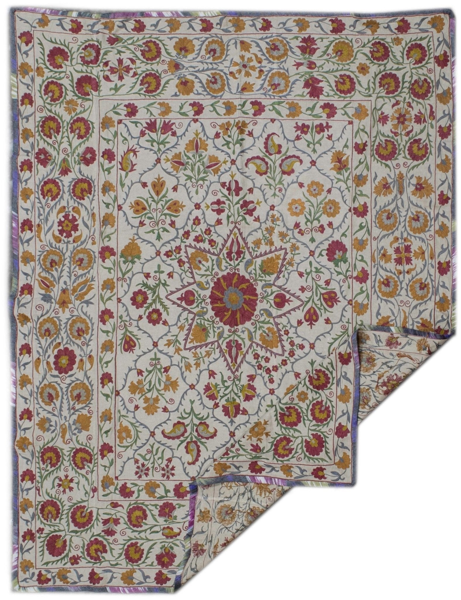 Handmade Uzbek suzani featuring intricate floral silk embroidery on a cream cotton base.