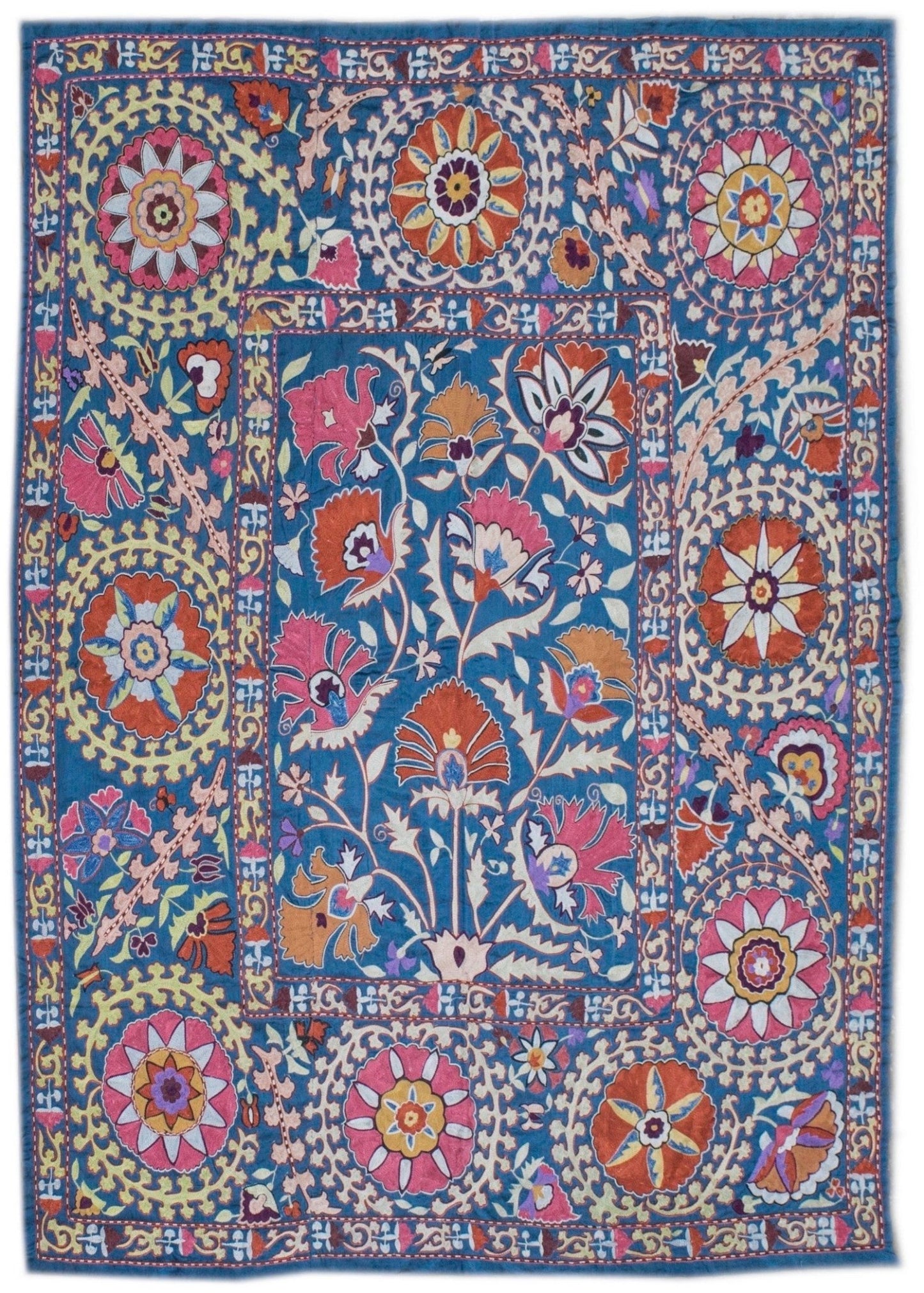 Handmade silk Uzbek suzani featuring intricate floral embroidery on a blue silk background.