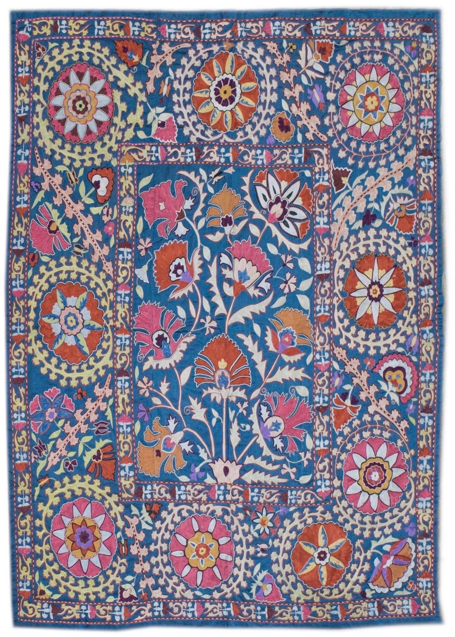 Handmade silk Uzbek suzani featuring intricate floral embroidery on a blue silk background.