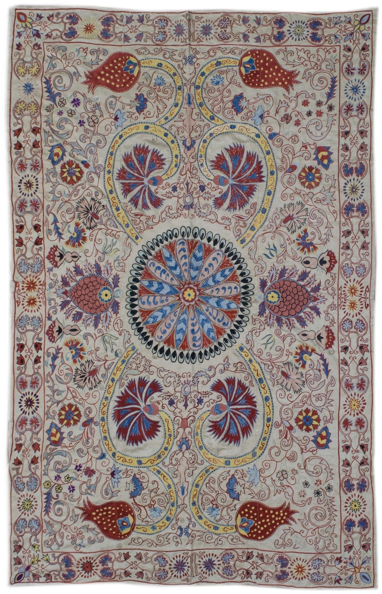 Handmade silk Uzbek suzani featuring intricate floral and pomegranate embroidery on a silk base.