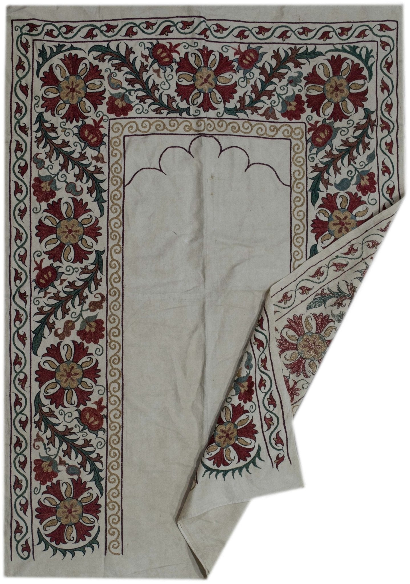 Handmade Uzbek suzani featuring intricate silk floral embroidery on a cream cotton base.