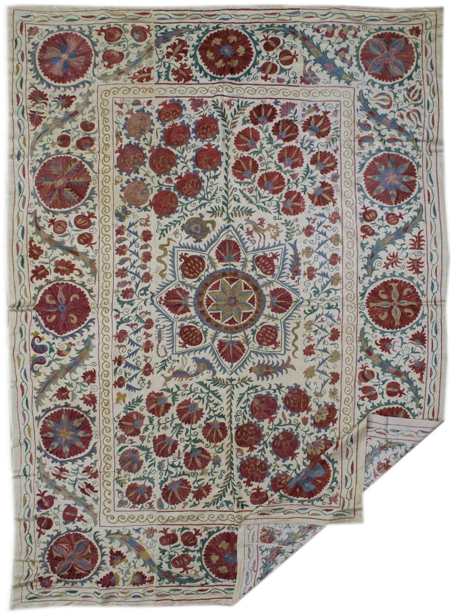 Handmade silk Uzbek suzani featuring intricate floral and pomegranate embroidery on a cream base.