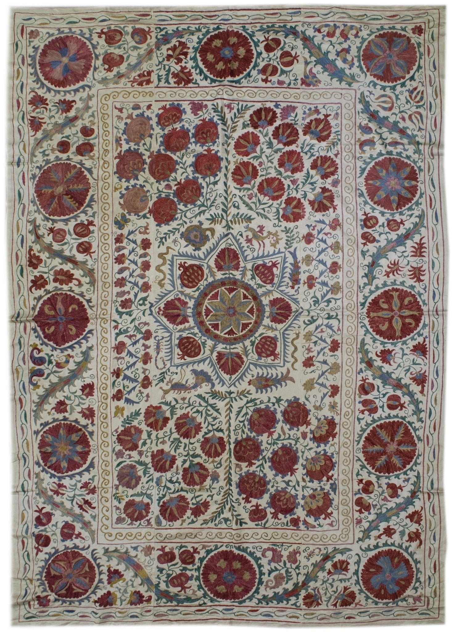 Handmade Uzbek suzani featuring intricate silk floral and pomegranate embroidery on silk fabric.