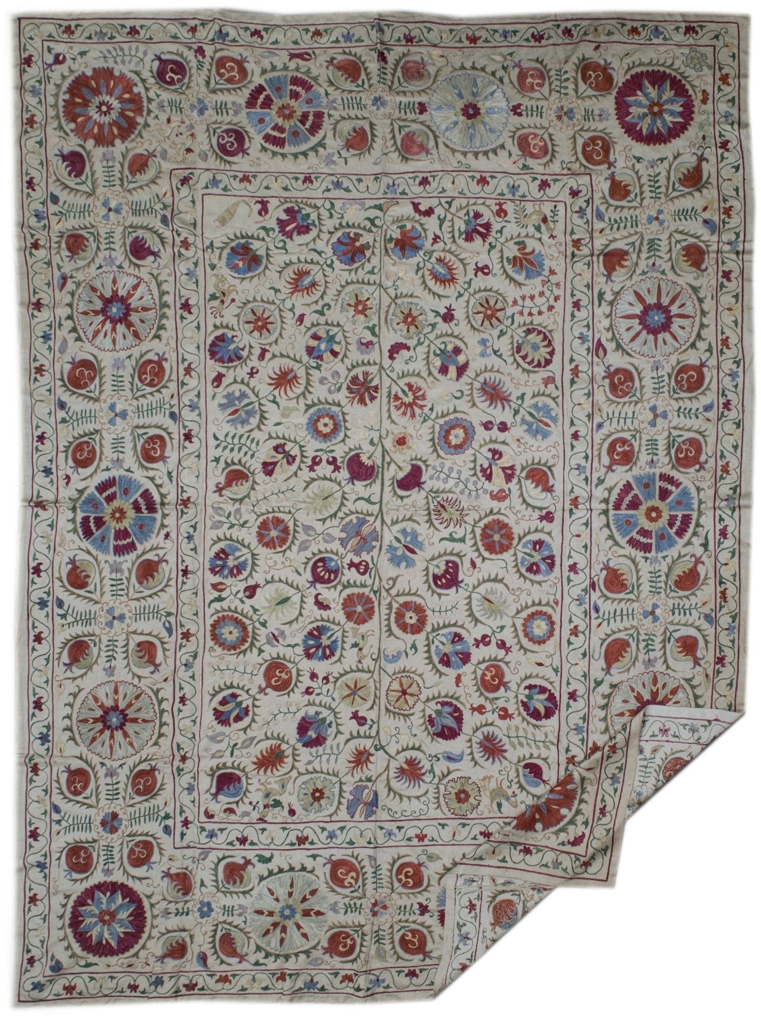 Handmade Uzbek suzani featuring intricate silk floral and pomegranate embroidery on silk fabric.