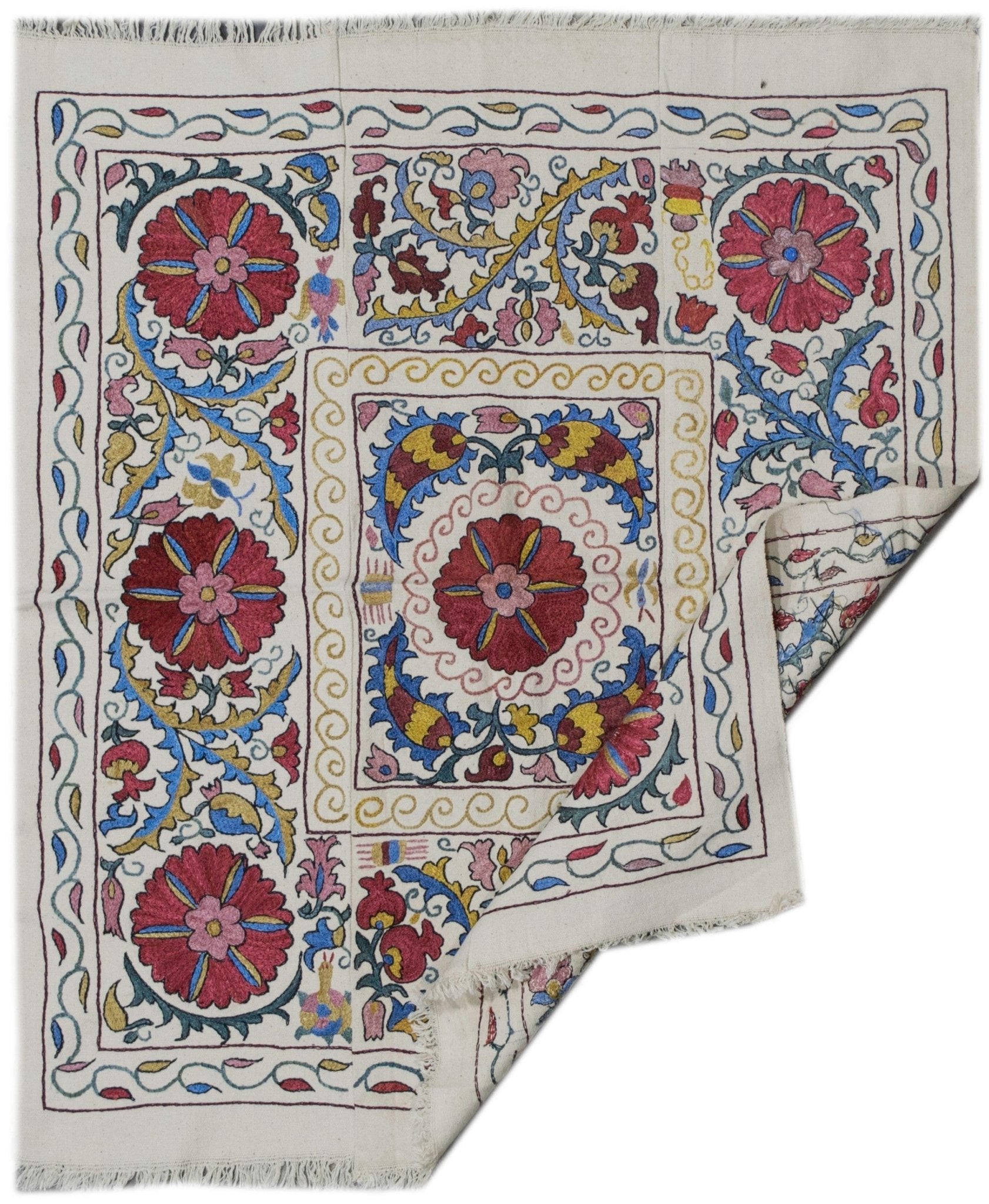 Handmade Uzbek suzani featuring colorful silk floral embroidery on a white cotton fabric base.