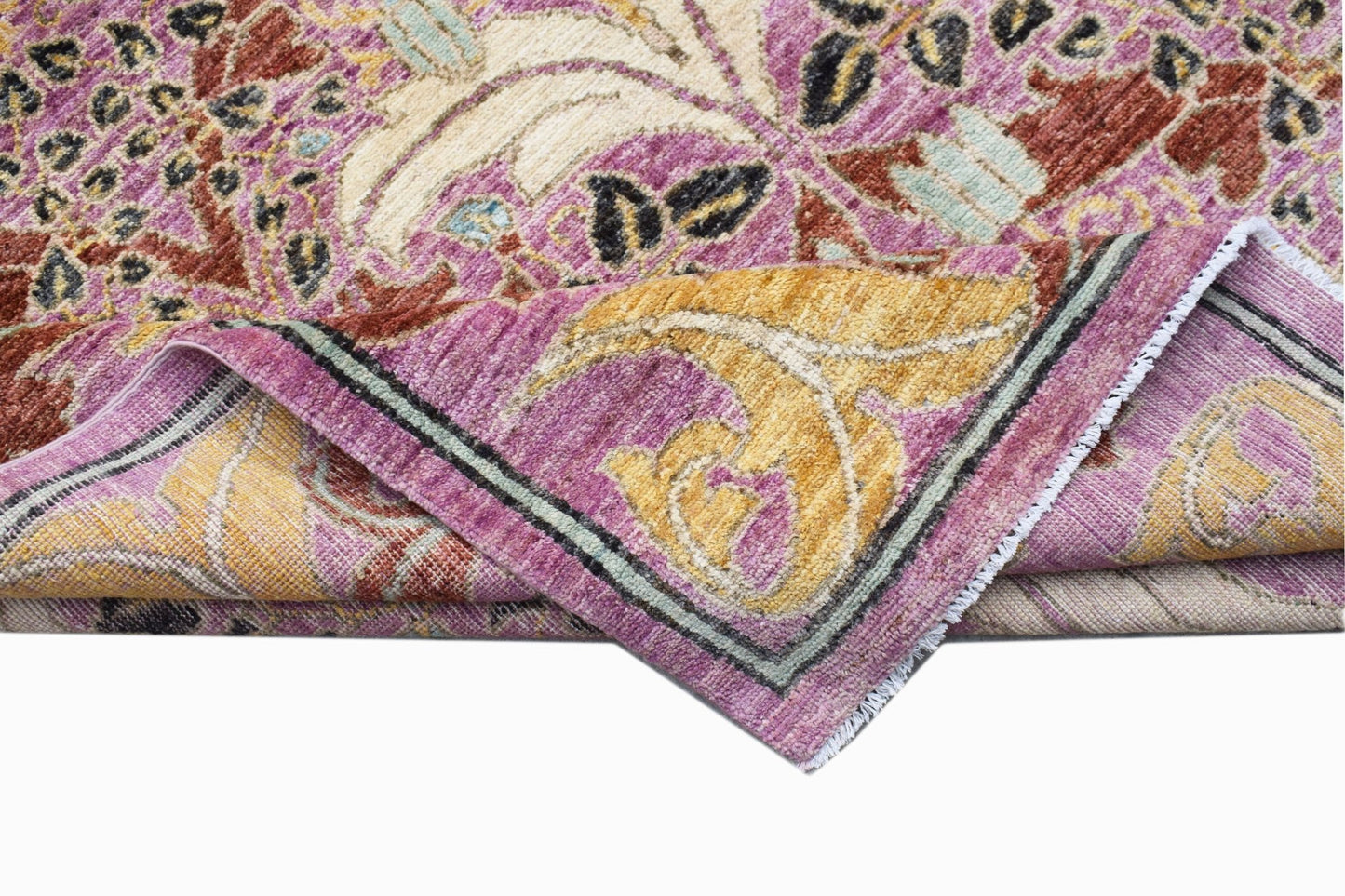 A handwoven Afghan rug featuring a floral botanical pattern in shades of pink, gold, and cream.