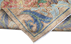A handwoven Afghan wool rug featuring a floral botanical pattern in blue, pink, and tan tones.