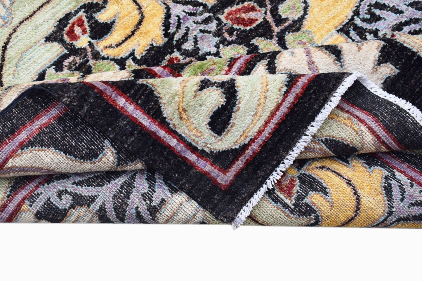 A handwoven Afghan wool rug featuring a transitional botanical pattern in black and yellow tones.