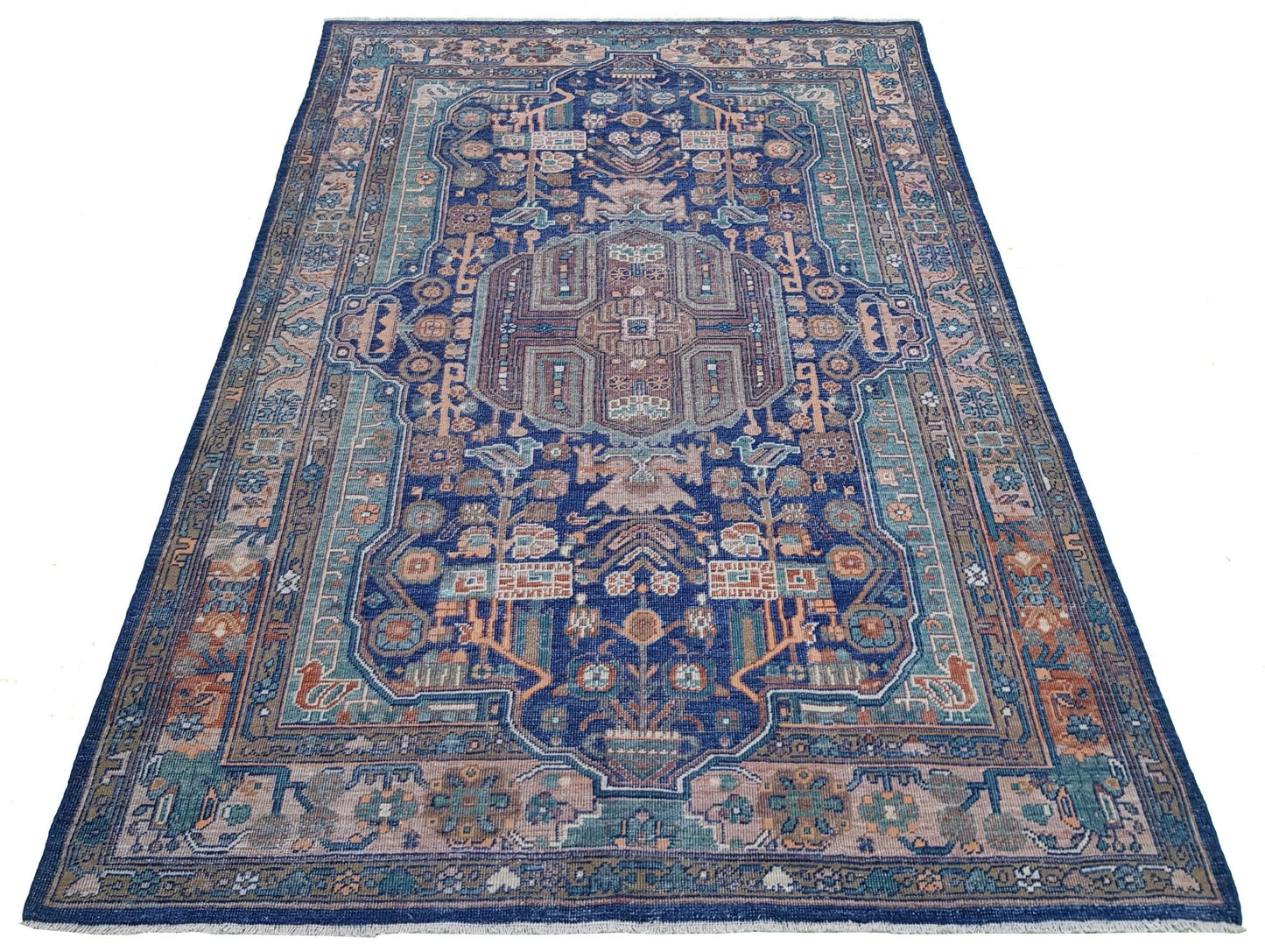 A rectangular Afghan rug featuring a traditional geometric pattern in blue, tan, and muted tones.