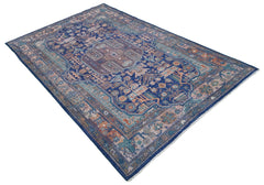 A rectangular Afghan rug featuring a traditional geometric pattern in blue, tan, and muted tones.