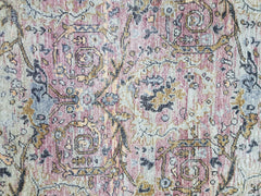 A transitional Oushak rug featuring a vintage-inspired floral pattern in muted pink and gold tones.