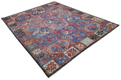 A handmade Afghan rug featuring a traditional geometric pattern in shades of red, blue, and pink.