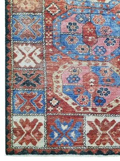 A handwoven Afghan rug featuring a geometric pattern in shades of red, blue, and cream.