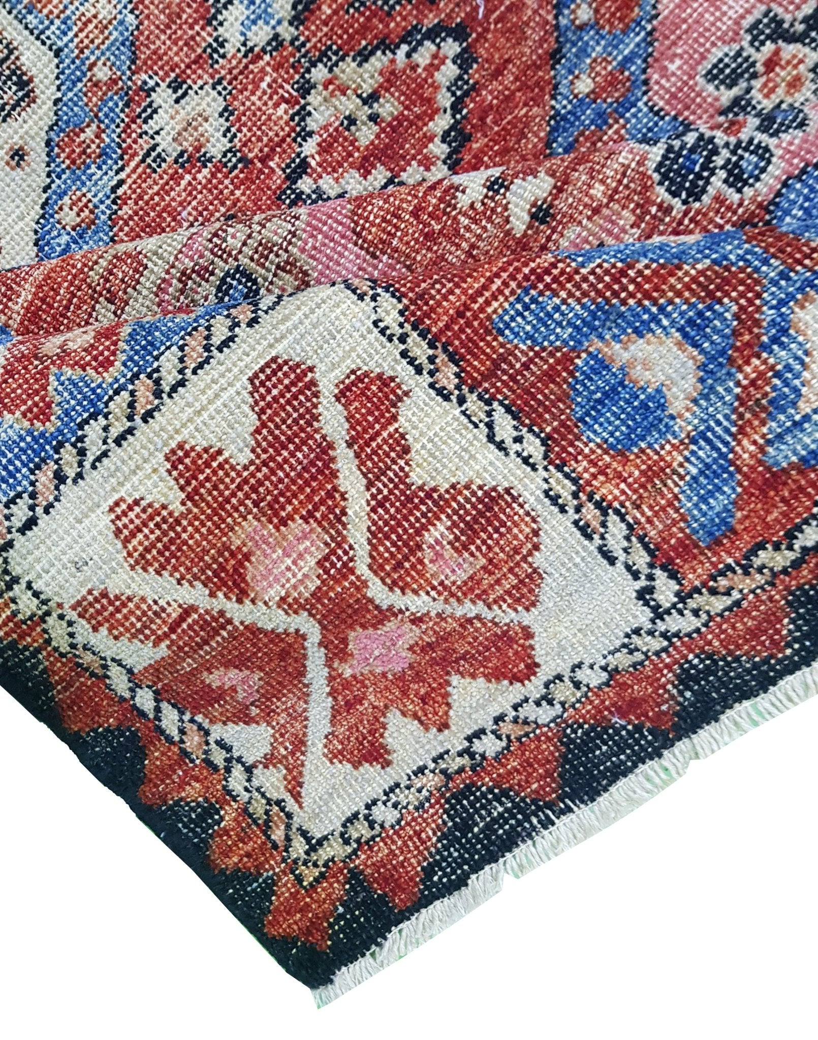 A handwoven Afghan rug featuring a traditional geometric pattern in red, blue, and cream tones.