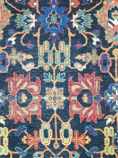 A transitional Afghan rug featuring a dark blue field with intricate floral and medallion motifs.