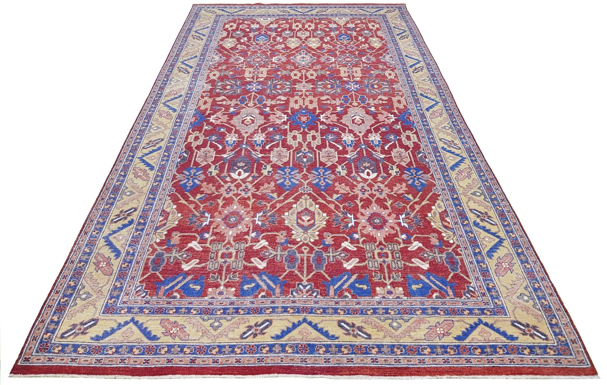 A rectangular transitional Afghan rug featuring a red field with a floral medallion and blue borders.