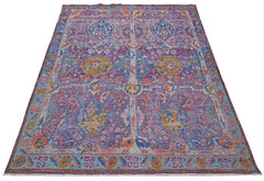 A handmade Afghan wool rug featuring a colorful, transitional Tree of Life garden pattern.