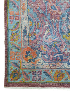 A handmade Afghan rug featuring a traditional Tree of Life pattern in vibrant blue and pink tones.