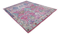A rectangular Afghan rug featuring a vibrant pink and blue floral Tree of Life pattern.