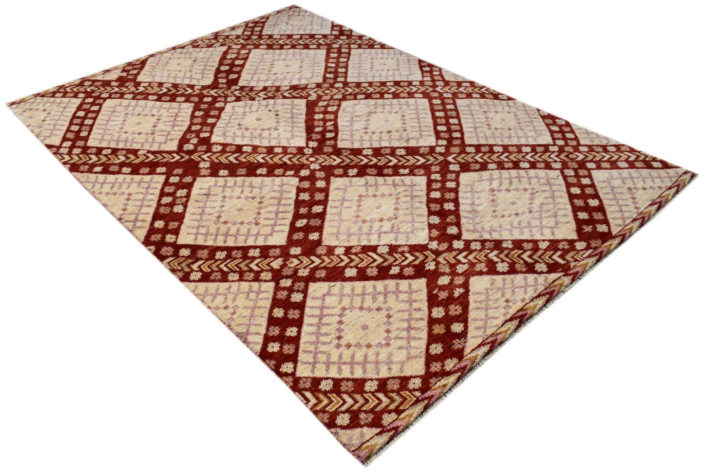 A hand-knotted wool rug featuring a geometric grid pattern in cream, light purple, and deep red.