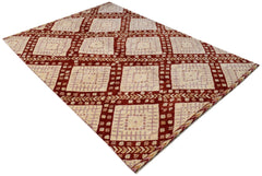 A hand-knotted wool rug featuring a geometric grid pattern in cream, light purple, and deep red.