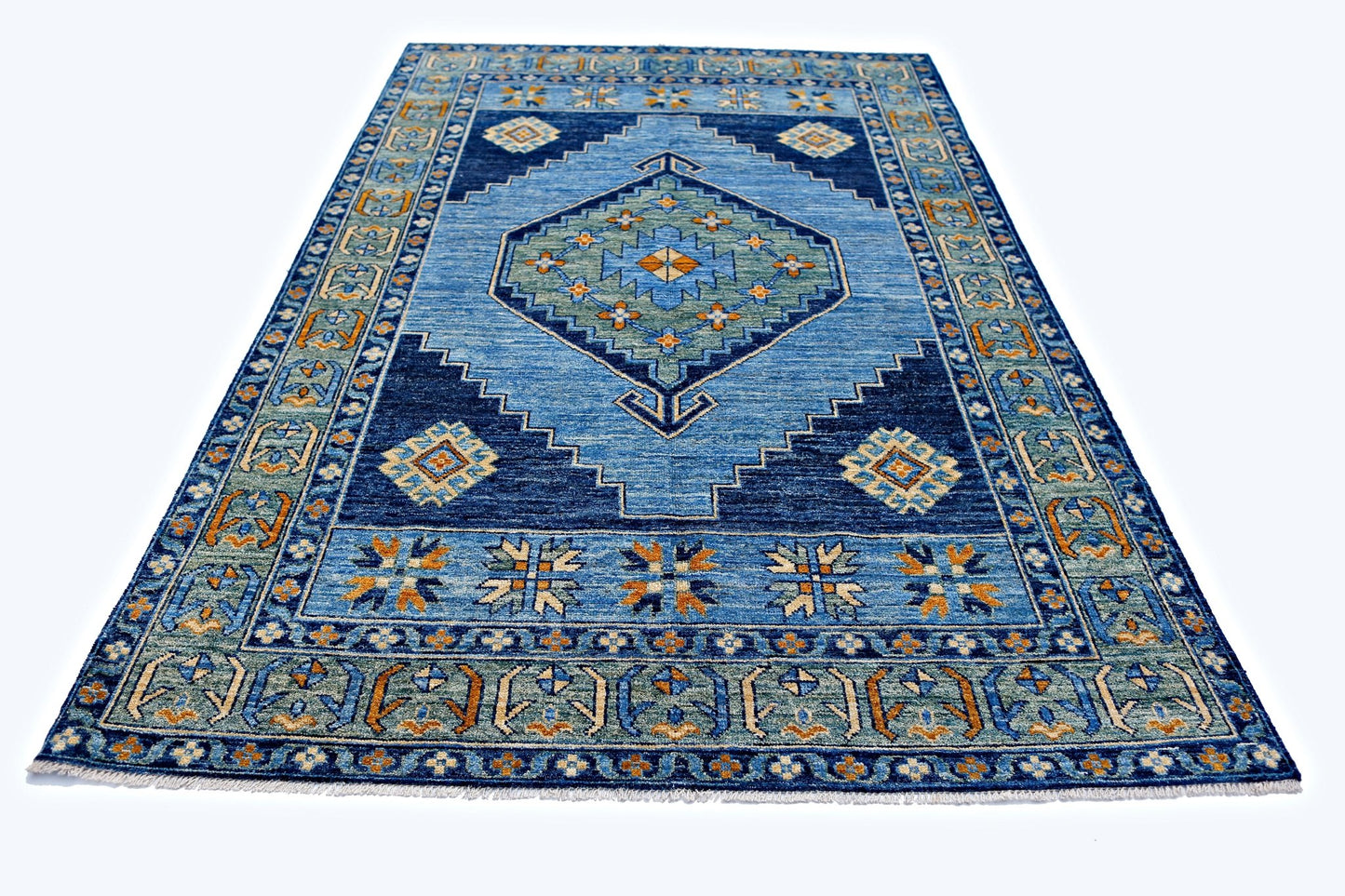 A handmade transitional Kohi rug featuring a blue geometric pattern with orange and green accents.
