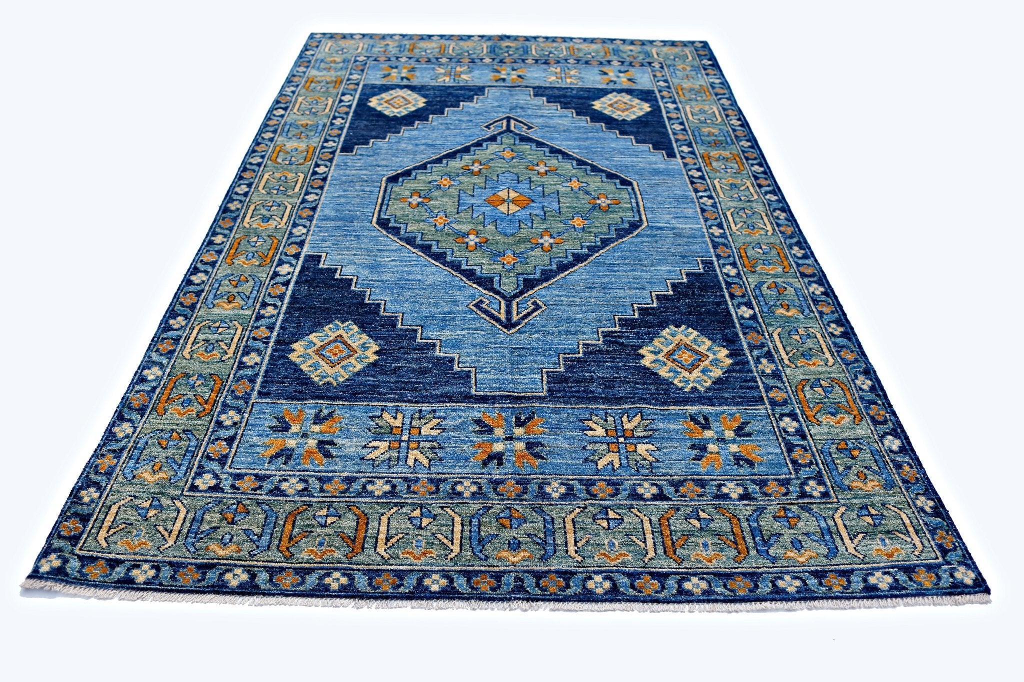 A handmade transitional Kohi rug featuring a blue geometric pattern with orange and green accents.