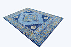 A handmade transitional Kohi rug featuring a blue geometric pattern with intricate floral motifs.