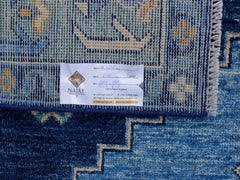 A close-up view of a blue transitional Kohi rug featuring a detailed geometric pattern.