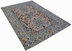 A hand-knotted wool rug featuring a grey background with intricate floral and geometric patterns.