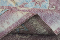 A corner of a handmade wool rug from Afghanistan showing its plush pile and woven backing.
