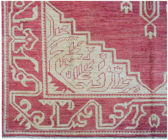A handmade Afghan wool rug featuring a geometric cream pattern on a vibrant pink background.