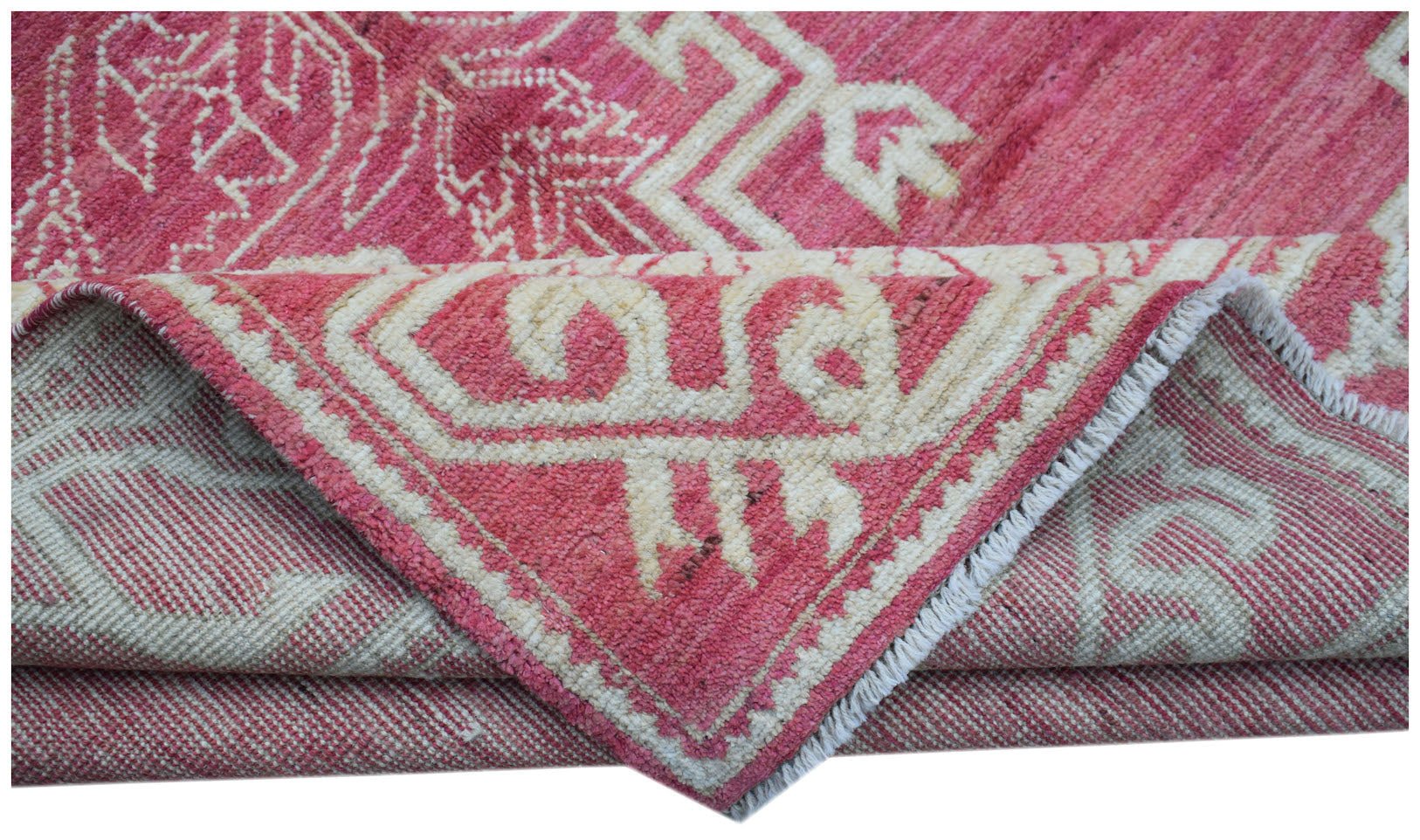A handmade wool rug from Afghanistan featuring a geometric pattern in shades of pink and cream.