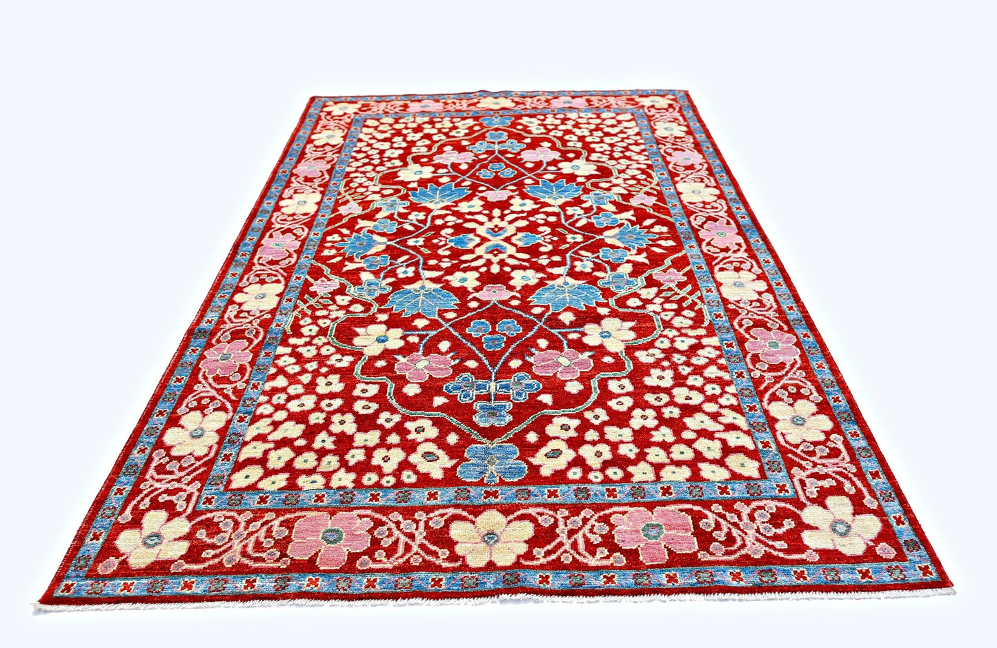 A handmade Afghan wool rug featuring a floral pattern in red, blue, and cream tones.