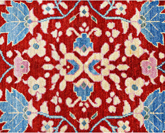 A handmade wool rug from Afghanistan featuring a symmetrical floral pattern in red, blue, and cream.