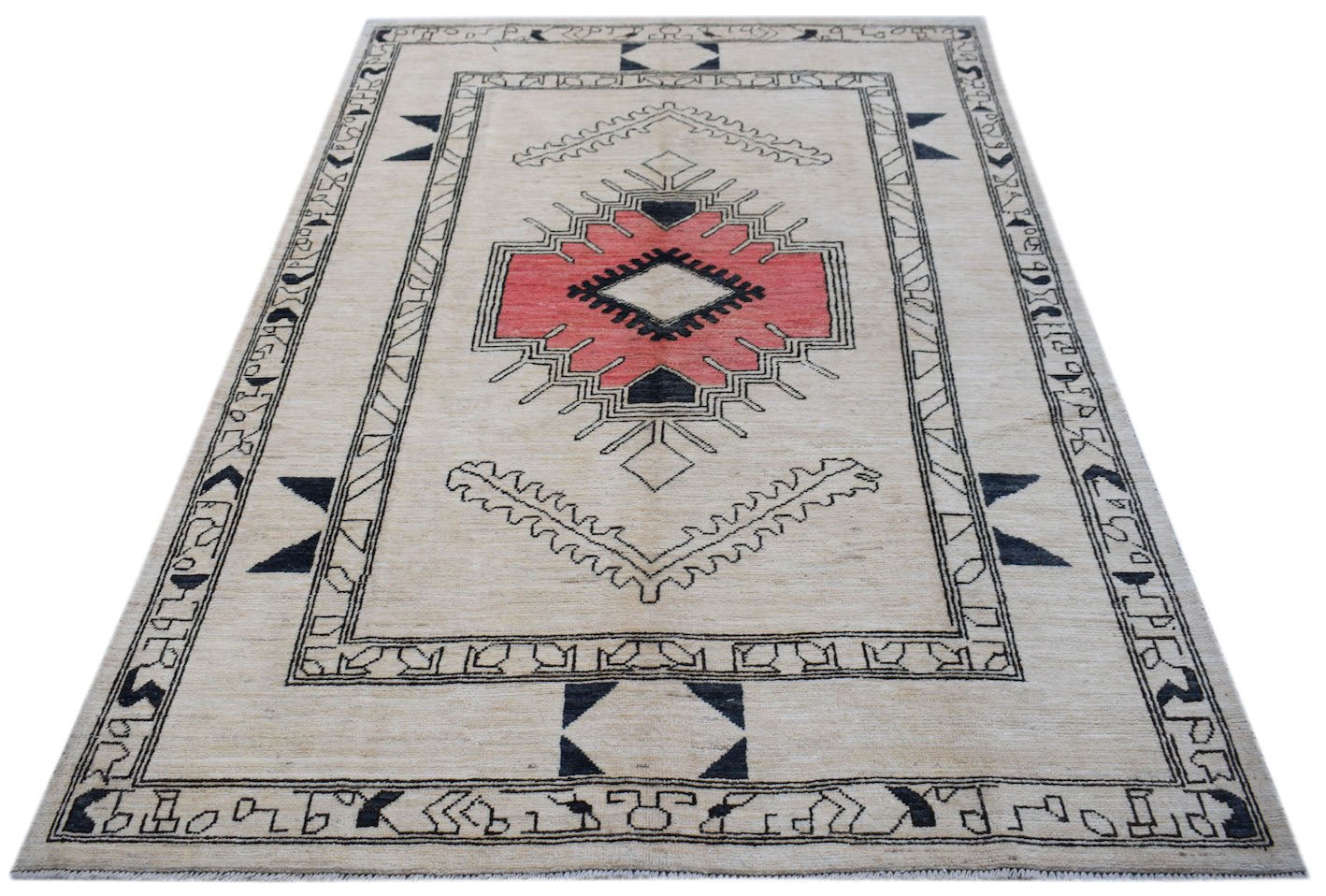 A handmade wool rug from Afghanistan featuring a central pink geometric medallion on a cream field.