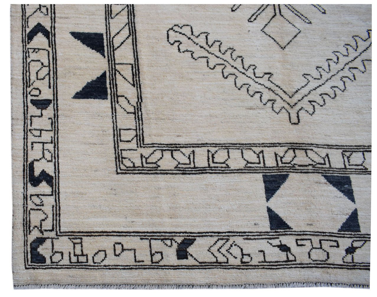 A handmade Afghan wool rug featuring a cream background with black geometric tribal patterns.