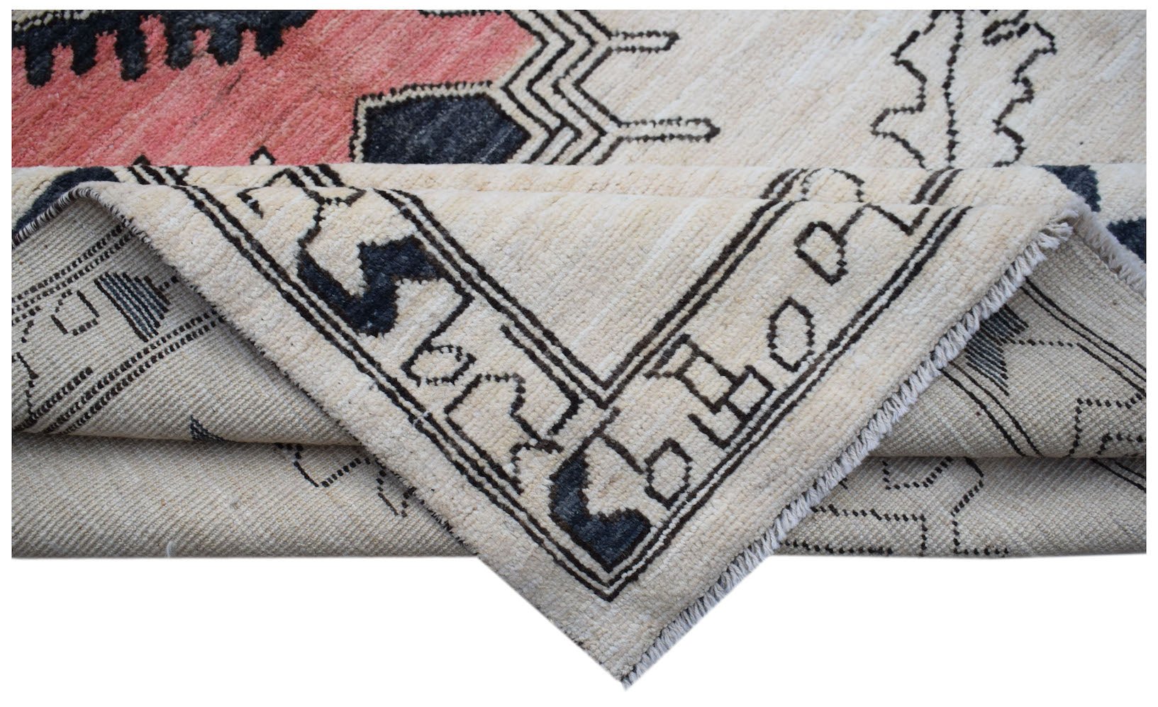 A corner of a handmade wool Transitional Kohi rug featuring a geometric pattern in cream and black.
