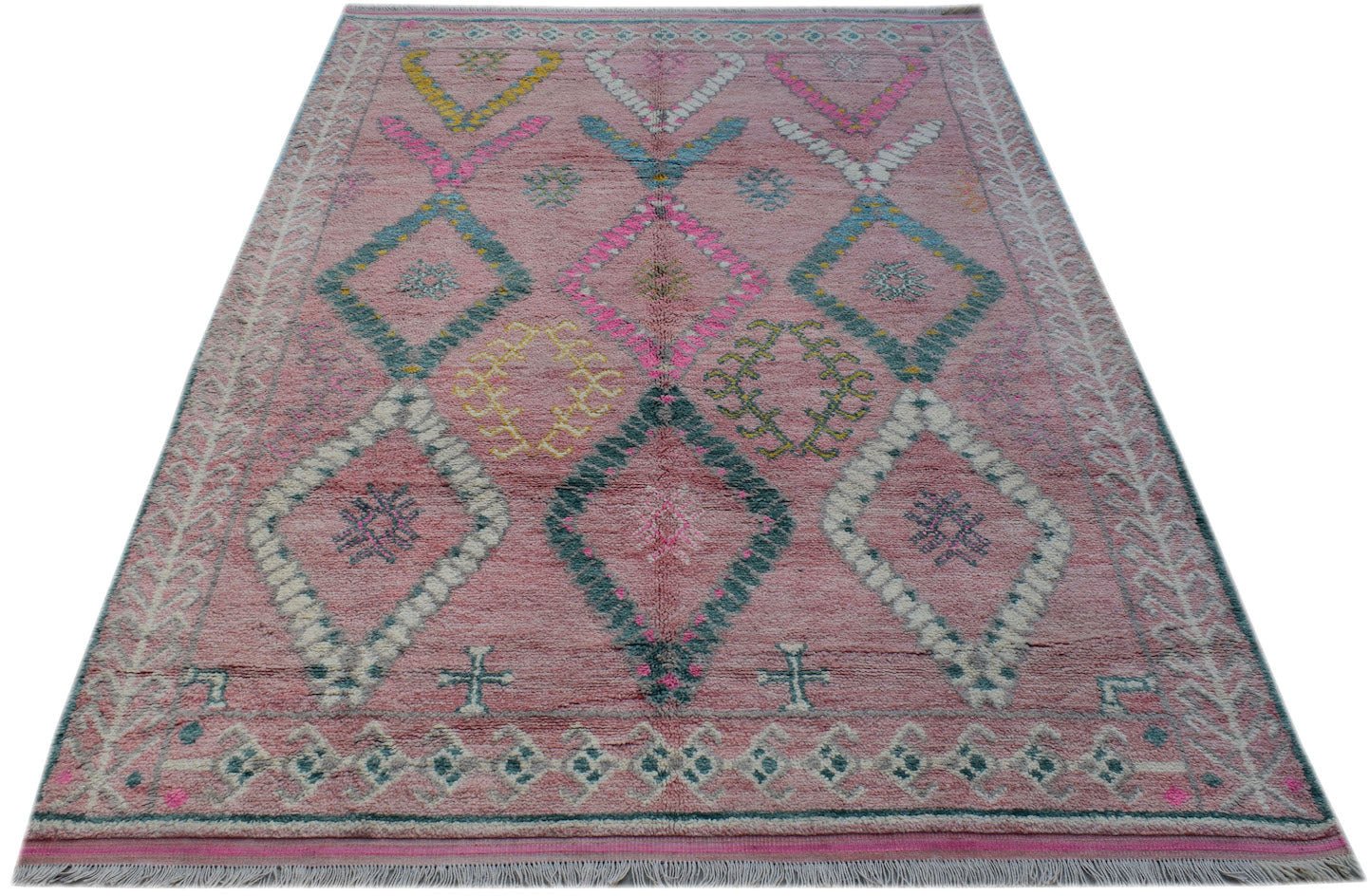 A handmade Afghan wool rug featuring a pink background with colorful geometric diamond patterns.