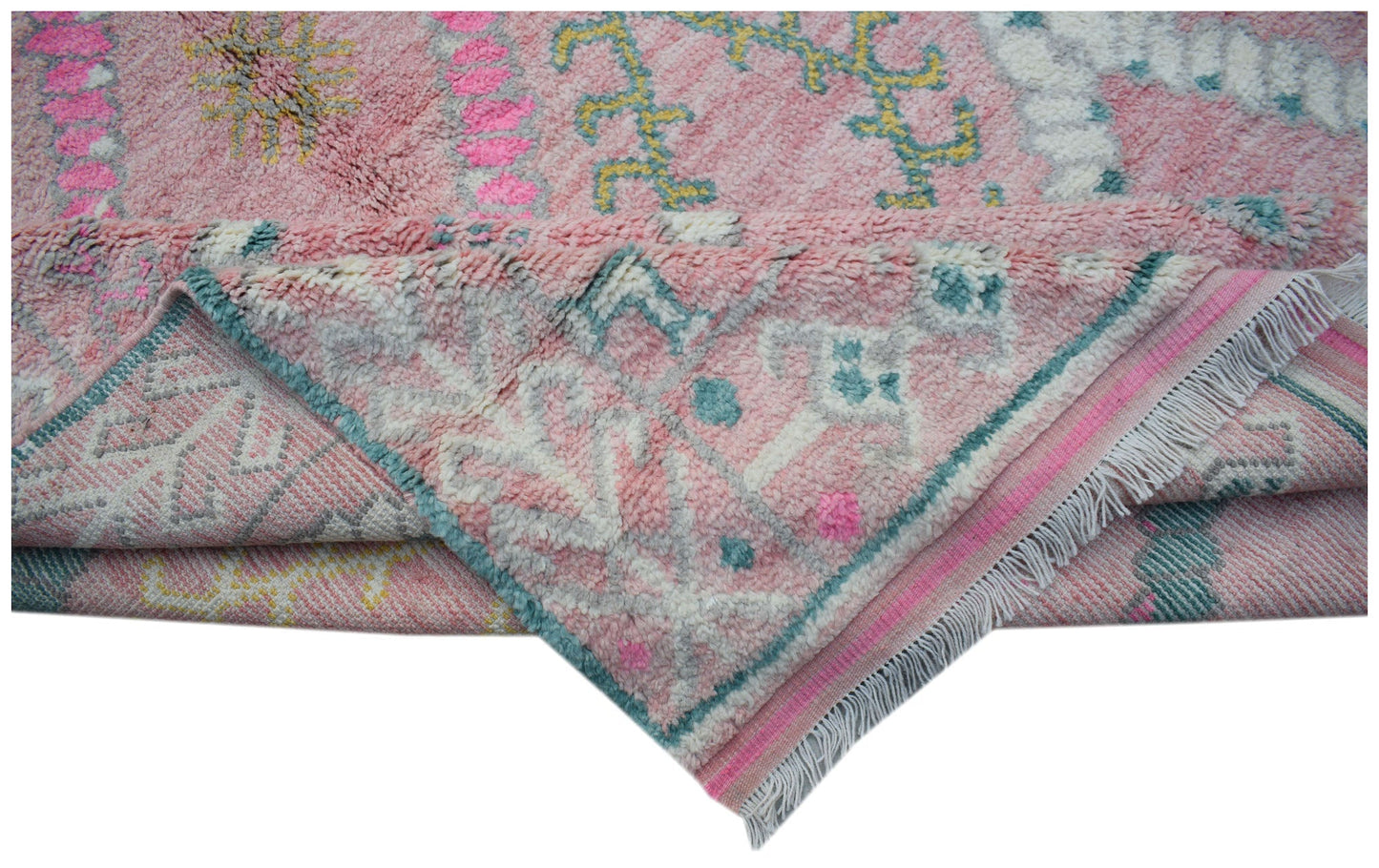A handmade transitional wool rug in pink with colorful tribal patterns and fringed edges.
