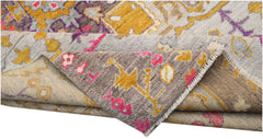 A hand-knotted wool rug featuring a transitional geometric pattern in grey, yellow, and pink.