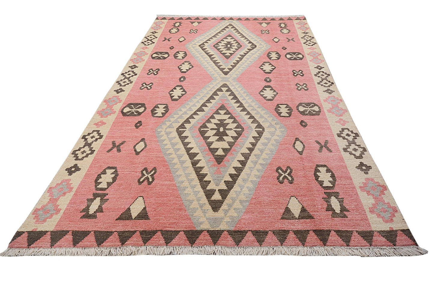 A handmade wool rug featuring a large central diamond pattern in shades of pink, grey, and brown.