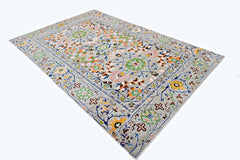 A handmade transitional Kohi rug featuring a light grey field with colorful floral motifs.
