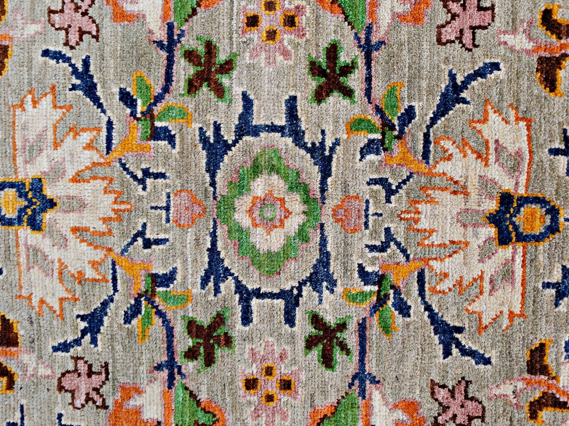 A handmade transitional Kohi rug featuring a detailed floral pattern in muted earth tones.