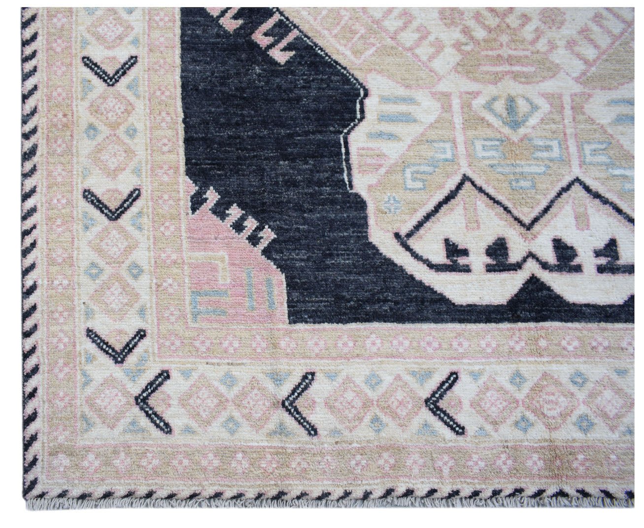 A handmade wool rug featuring a geometric tribal pattern in navy, pink, and cream tones.