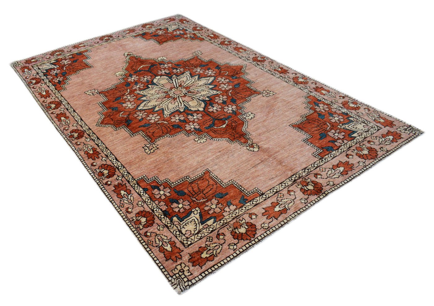 Handmade Afghan Kohi wool rug featuring a central floral medallion on a dusty pink background.